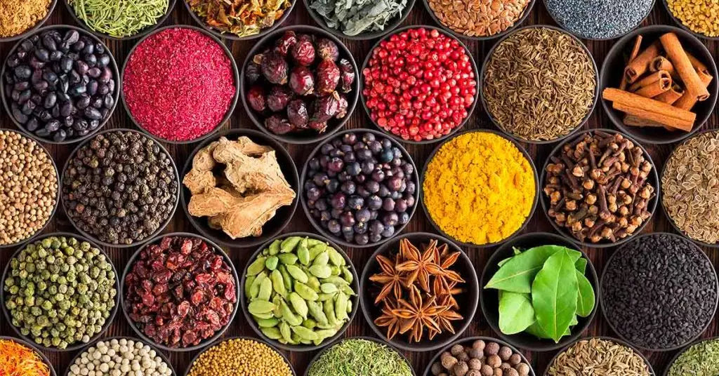 A vibrant selection of whole spices, seeds, herbs and spice powders